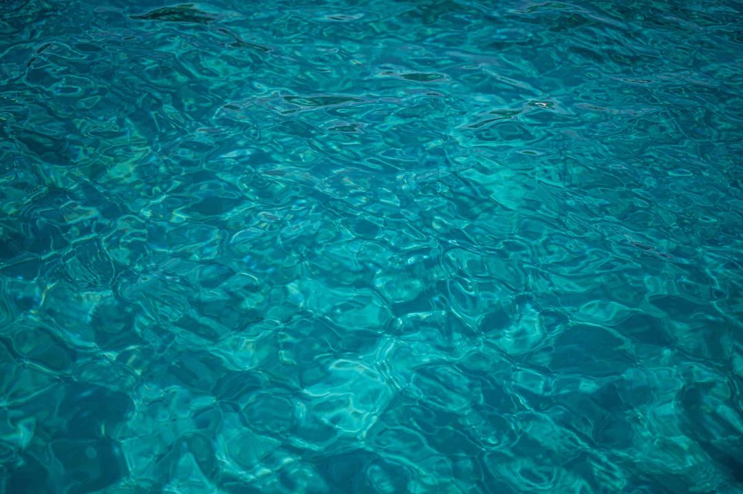 Clear turquoise sea water with rippling light patterns, the colour of the shallows you swim in when sailing Sithonia